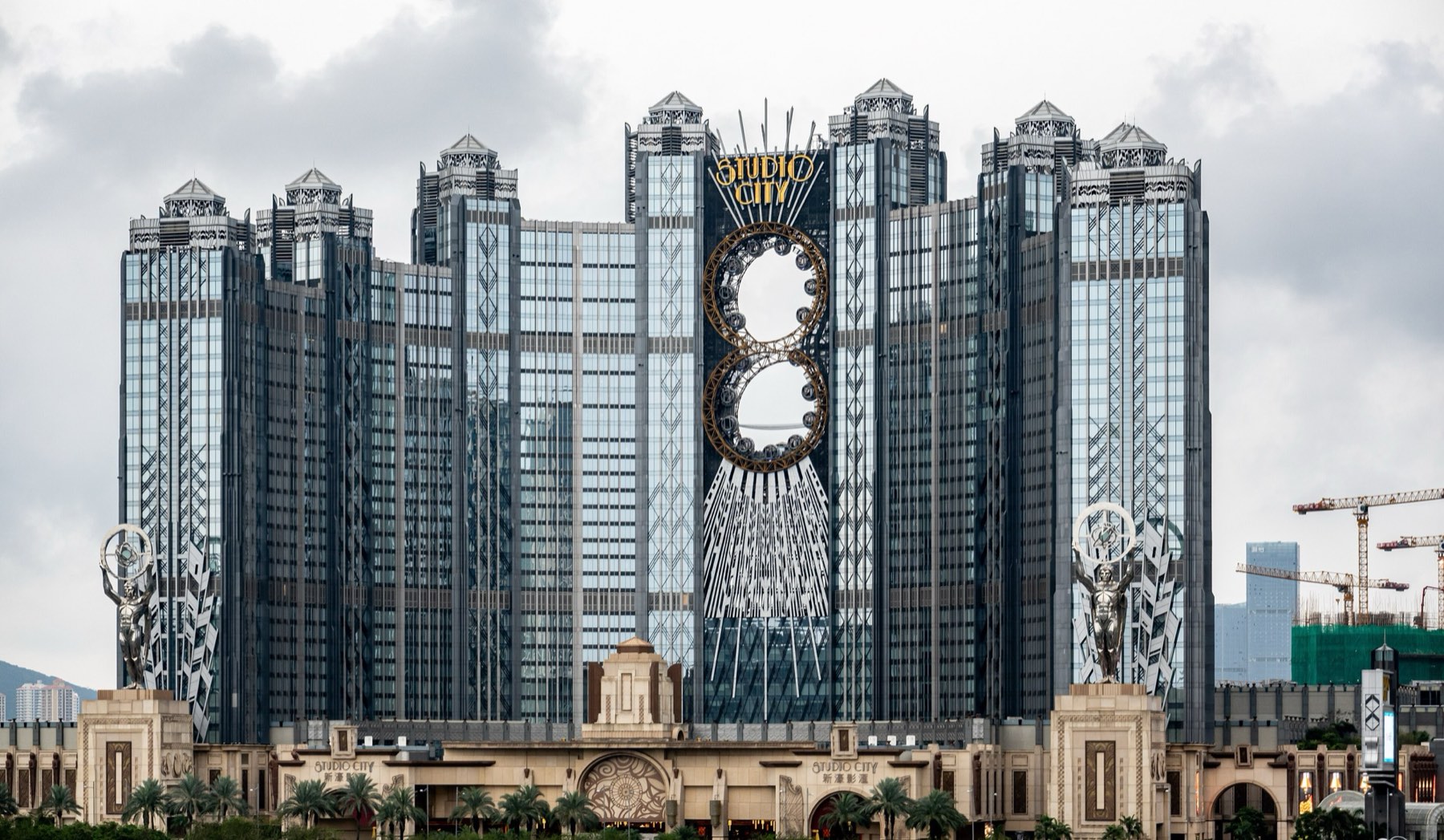 Studio City Macau’s art deco hotel towers with the gold figure-of-eight Golden Reel Ferris wheel set between them